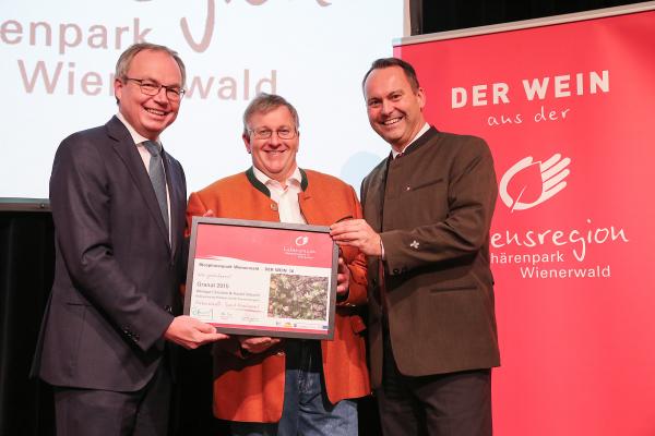 Landesrat Dr. Stephan Pernkopf (l.) und Forstdirektor der Stadt Wien DI Andreas Januskovecz (r.) gratulieren dem Weingut Harald & Christine Schachl zum Kategoriesieger Thermenregion Rotwein leicht.