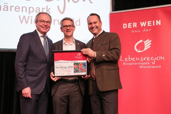 Landesrat Dr. Stephan Pernkopf (l.) und Forstdirektor der Stadt Wien DI Andreas Januskovecz (r.) gratulieren dem Weingut Stift Klosterneuburg zum Top-Winzer.