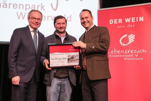 Landesrat Dr. Stephan Pernkopf (l.) und Forstdirektor der Stadt Wien DI Andreas Januskovecz (r.) gratulieren dem Weingut Walter zum Top-Winzer.