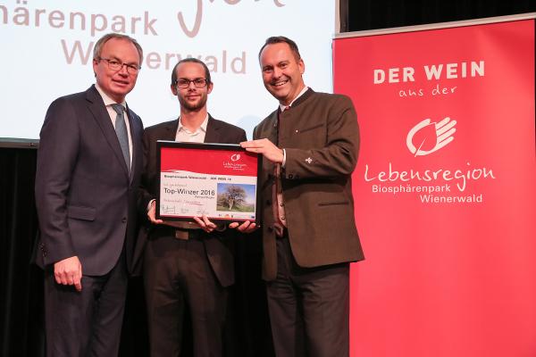 Landesrat Dr. Stephan Pernkopf (l.) und Forstdirektor der Stadt Wien DI Andreas Januskovecz (r.) gratulieren dem Weingut Biegler zum Top-Winzer.