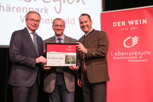 Landesrat Dr. Stephan Pernkopf (l.) und Forstdirektor der Stadt Wien DI Andreas Januskovecz (r.) gratulieren dem Weingut Schaflerhof zum Top-Winzer.