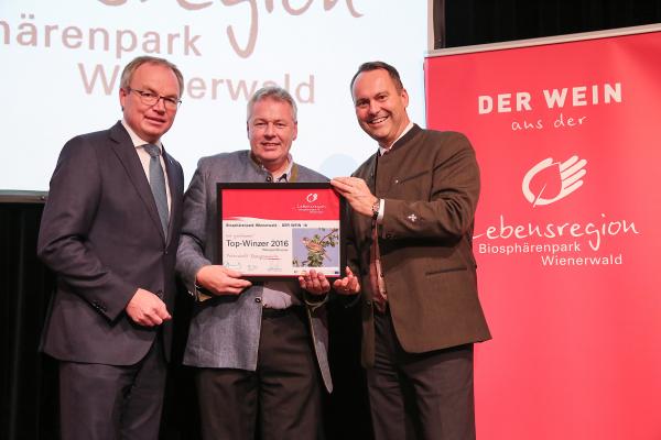 Landesrat Dr. Stephan Pernkopf (l.) und Forstdirektor der Stadt Wien DI Andreas Januskovecz (r.) gratulieren dem Weingut Strasser zum Top-Winzer.