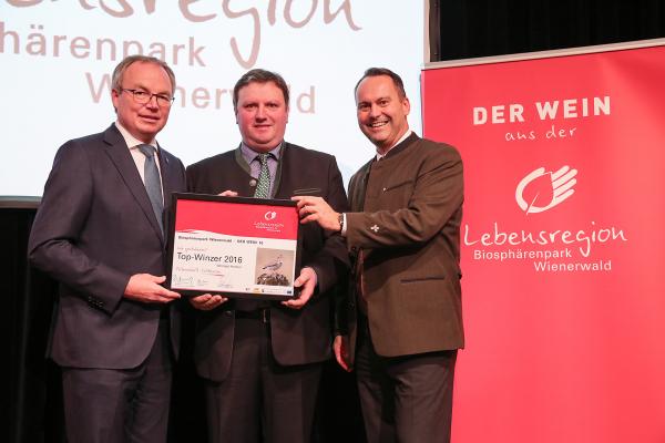 Landesrat Dr. Stephan Pernkopf (l.) und Forstdirektor der Stadt Wien DI Andreas Januskovecz (r.) gratulieren dem Weingut Strasser zum Top-Winzer.