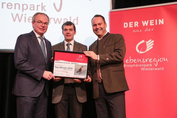 Landesrat Dr. Stephan Pernkopf (l.) und Forstdirektor der Stadt Wien DI Andreas Januskovecz (r.) gratulieren dem Weingut Schlossberg zum Top-Winzer.