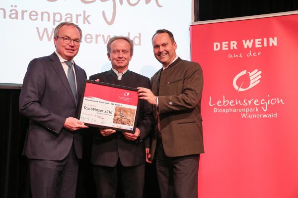 Landesrat Dr. Stephan Pernkopf (l.) und Forstdirektor der Stadt Wien DI Andreas Januskovecz (r.) gratulieren dem Brunngassenheuriger zum Top-Winzer.