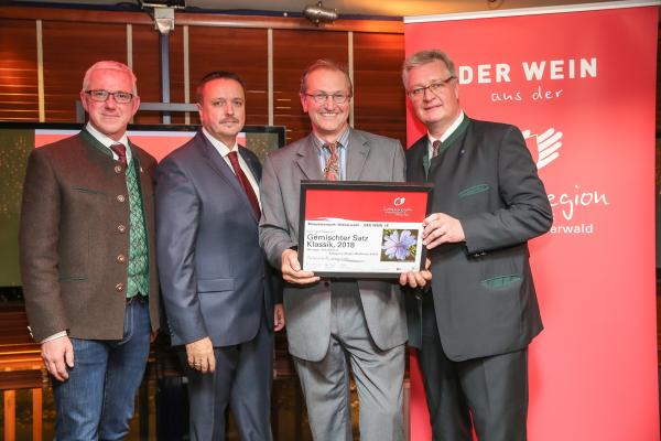 Biosphärenpark Direktor DI Andreas Weiß (l.), Wiener LAbg. Ernst Holzmann (2.v.l.) und NÖ LAbg. Christoph Kainz (r.) gratulieren dem Weingut Schaflerhof zum  Kategoriesieg Weißwein leicht.