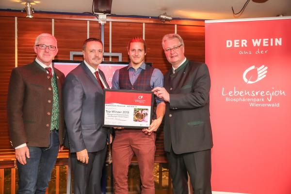 Biosphärenpark Direktor DI Andreas Weiß (l.), Wiener LAbg. Ernst Holzmann (2.v.l.) und NÖ LAbg. Christoph Kainz (r.) gratulieren dem Weingut und Buschenschank und Heuriger Fischer-Kügerl zum Top-Winzer 2019.