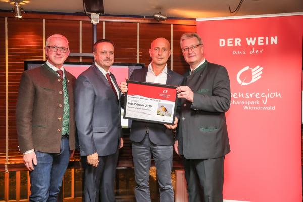 Biosphärenpark Direktor DI Andreas Weiß (l.), Wiener LAbg. Ernst Holzmann (2.v.l.) und NÖ LAbg. Christoph Kainz (r.) gratulieren dem Weingut Gebeshuber zum Top-Winzer 2019.