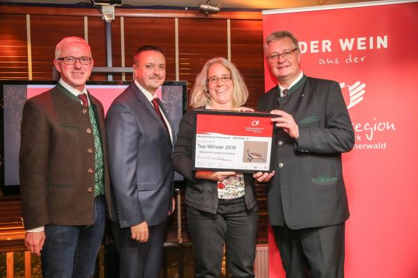 Biosphärenpark Direktor DI Andreas Weiß (l.), Wiener LAbg. Ernst Holzmann (2.v.l.) und NÖ LAbg. Christoph Kainz (r.) gratulieren dem Weingut Landauer-Gisperg zum Top-Winzer 2019.
