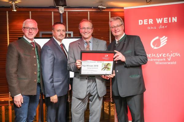 Biosphärenpark Direktor DI Andreas Weiß (l.), Wiener LAbg. Ernst Holzmann (2.v.l.) und NÖ LAbg. Christoph Kainz (r.) gratulieren dem Weingut Schaflerhof zum Top-Winzer 2019.