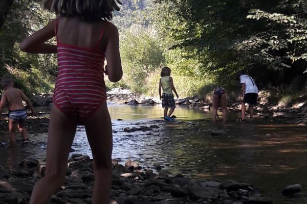 Kinder spielen beim Bach