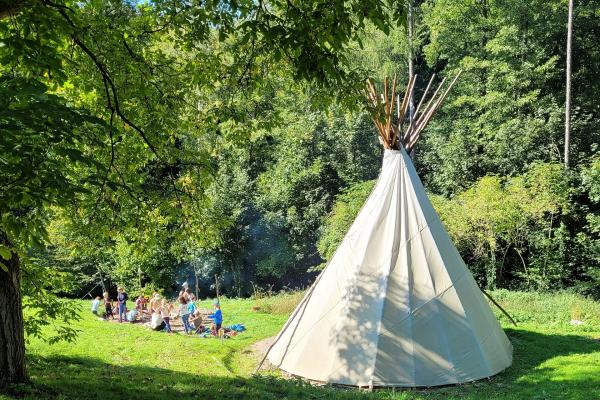 Tipi mit Kindern auf Waldlichtung