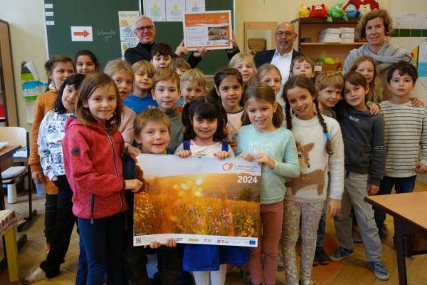 Biosphärenpark-Direktor Andreas Weiß und Bezirksvorsteher Peter Jagsch überreichen als Dankeschön die Urkunden an die Schüler und Schülerinnen der Klasse 2a der Volksschule Knollgasse, mit der Klassenlehrerin Alexandra Krispa.