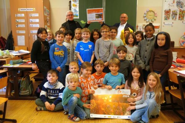 Biosphärenpark-Direktor Andreas Weiß und Bezirksvorsteher Peter Jagsch überreichen als Dankeschön die Urkunden an die Schüler und Schülerinnen der Klasse 2d der Volksschule Knollgasse.