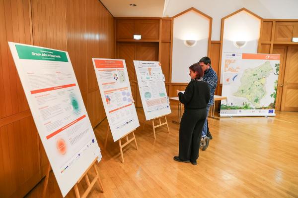 zwei Personen vor Plakaten