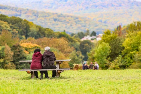 Menschen auf einer Bank von hinten mit Blick auf Wienerwald