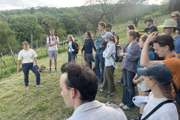 Gruppe mit Winzerin in Weinbaulandschaft