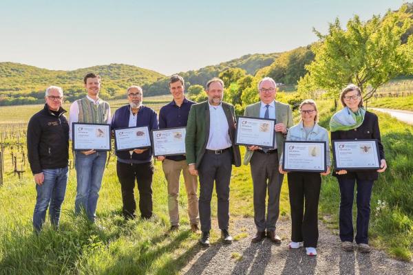 Biosphärenpark-Direktor DI Andreas Weiß (links außen) und NÖ LH-Stv. Dr. Stephan Pernkopf (3. v. re.) gratulieren den KategoriesiegerInnen 2026 (v.l.n.r.): Weinbau Karl Wölflinger, Weingut Familie Auer, Bio-Weingut Frühwirth, Weingut Stift Klosterneuburg, Wein & Heuriger Pferschy-Seper, Weinbau Barbach und Johannes Müller Stadweingut (nicht im Bild).