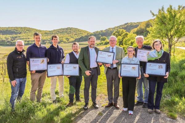 Biosphärenpark-Direktor DI Andreas Weiß (links außen) und NÖ LH-Stv. Dr. Stephan Pernkopf (4. v. re.) gratulieren den 7 Top-Weinbaubetrieben 2026 (v.l.n.r.): Bio-Weingut Frühwirth, Weinbau Zechmeister, Weinbau Beranek, Weingut Stift Klosterneuburg, Wein & Heuriger Pferschy-Seper, Schaflerhof, Weinbau Barbach.