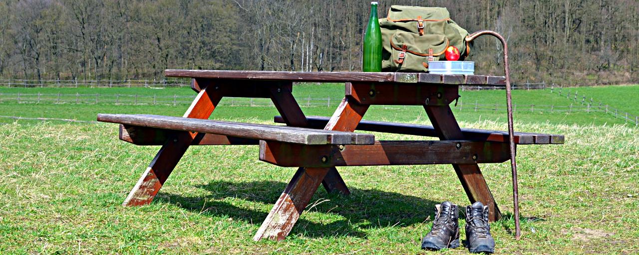 Wander- Rucksack, Schuhe, Stock und Jause auf einer Bank