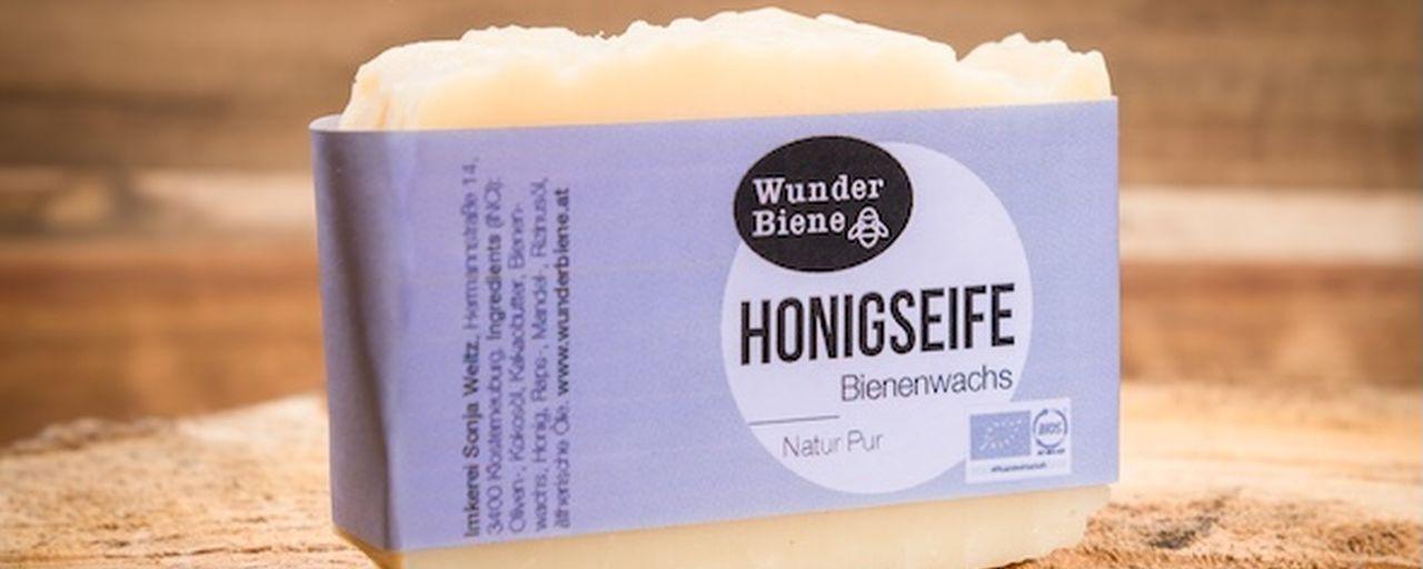 Seife mit blasslila Schleife auf Holzbank