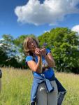 Ilse Wrbka-Fuchsig auf einer Wiese mit Wald im Hintergrund