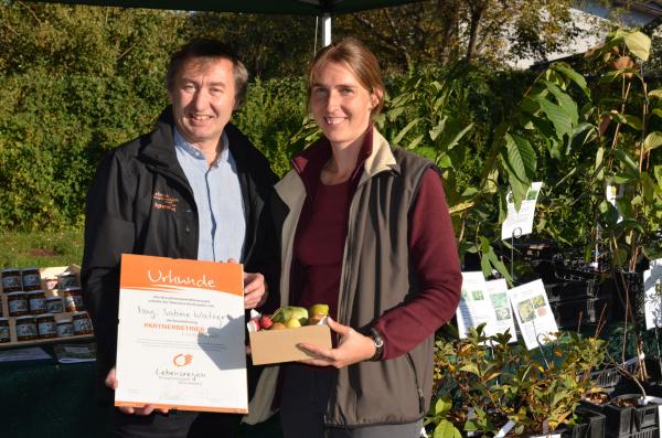 Dr. Herbert Greisberger, Direktor des Biosphärenpark Wienerwald, überreicht Mag.a Sabine Watzer die Partnerbetrieb-Urkunde.