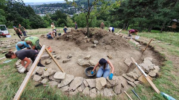 Personengruppe die eine Trockensteinmauer errichtet