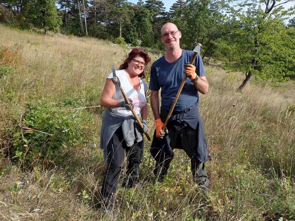 2 Menschen mit Werkzeug in Trockenrasenlandschaft