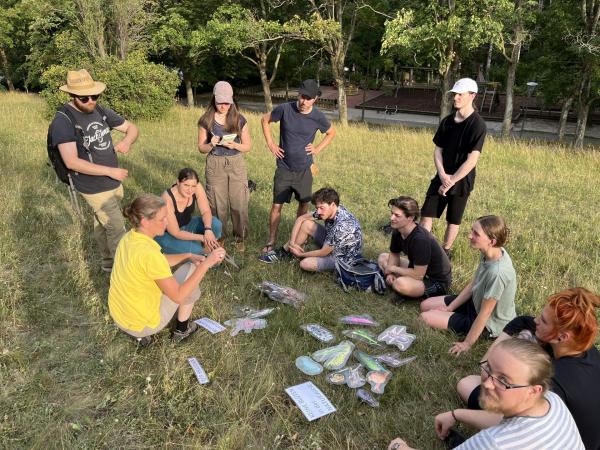 Gruppe auf Wiese mit Anschauungsmaterial