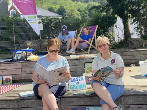 Menschen lesen auf Bänken