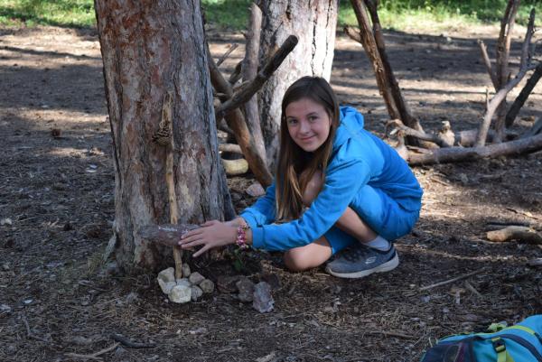 Mädchen in Wald mit Stockkonstruktion