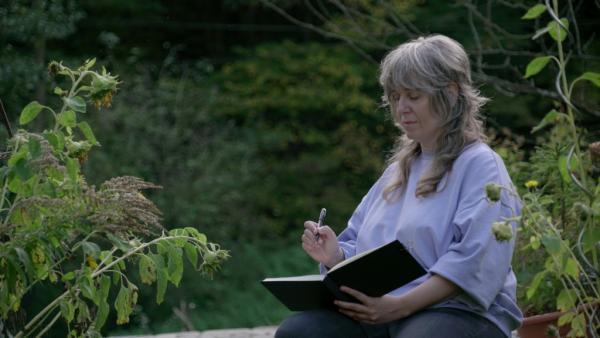 Frau zeichnet in Buch