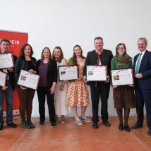 Wiener LAbg. Mag.a Nina Abrahamczik (4.v.li.), NÖ Landtagspräsident Mag. Karl Wilfing und Biosphärenpark-Direktor DI Andreas Weiß (beide rechts außen) gratulieren den 6 Top-Weinbaubetrieben 2023 (v.l.n.r.) Bio-Weingut Frühwirth, Weingut Mayer am Pfarrplatz, Weingut Ubl-Doschek, Weingut Hecher, Weinbau Barbach und Weingut Schneider (nicht im Bild).