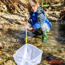 Bub mit Kescher im Bach