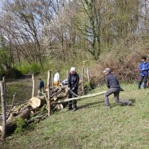Menschen errichten Hecke aus Naturmaterialien