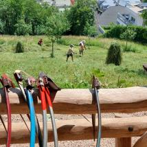 Menschen mähen Wiese mit Sense