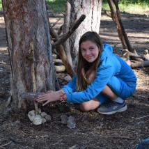 Mädchen in Wald mit Stockkonstruktion