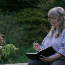 Frau zeichnet in Buch